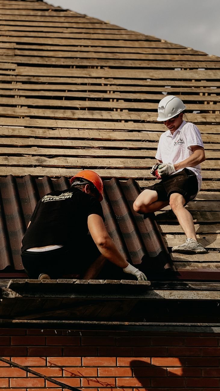 construction workers repairing roof tiles outdoors